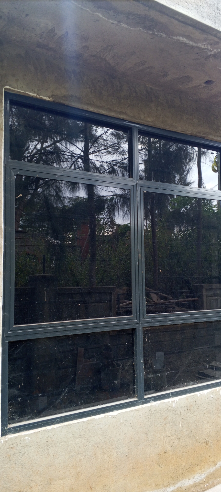 Wide aluminum awning window installation under a concrete overhang