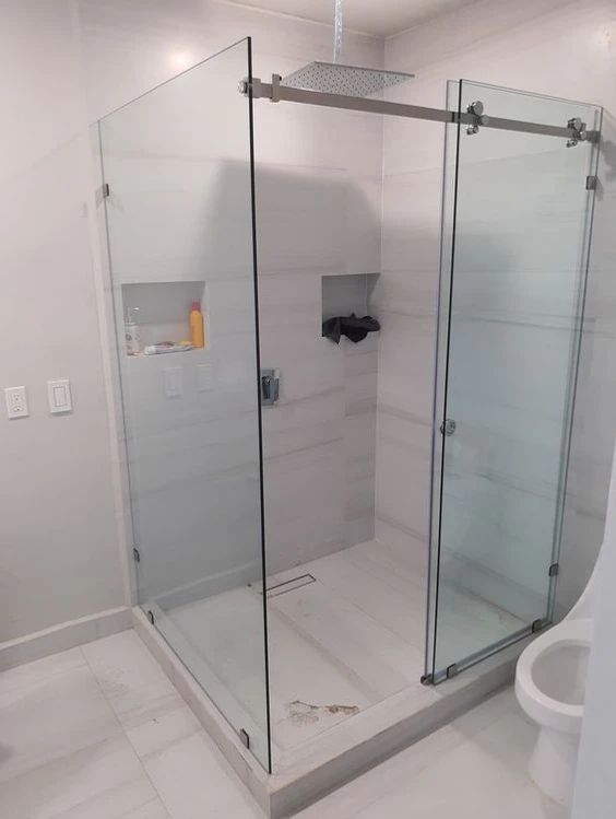 Sliding frameless shower enclosure with rain shower head