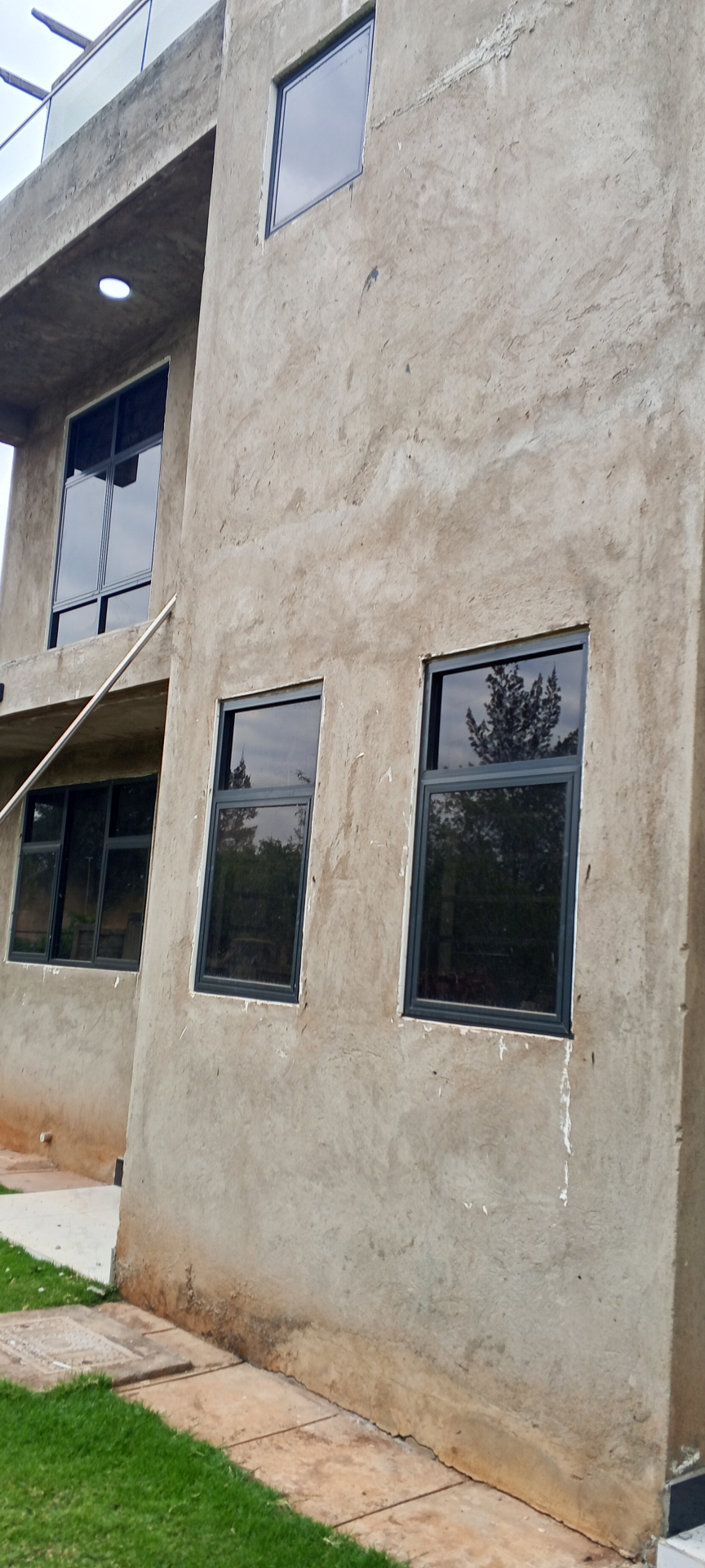 Aluminum awning windows with reflective glass on a textured exterior wall